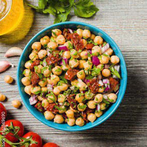 Chickpea salad in a bowl with herbs and tomatoes