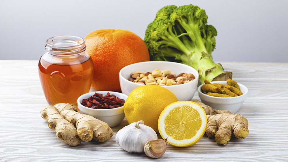 Photo of broccoli, orange, honey, ginger, garlic, lemon, and bowl of goji berries