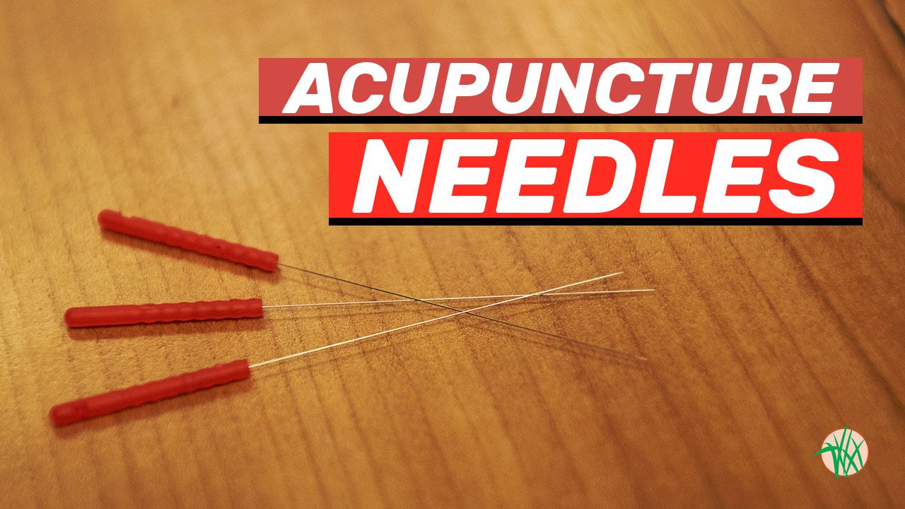 3 acupuncture needles against wooden background
