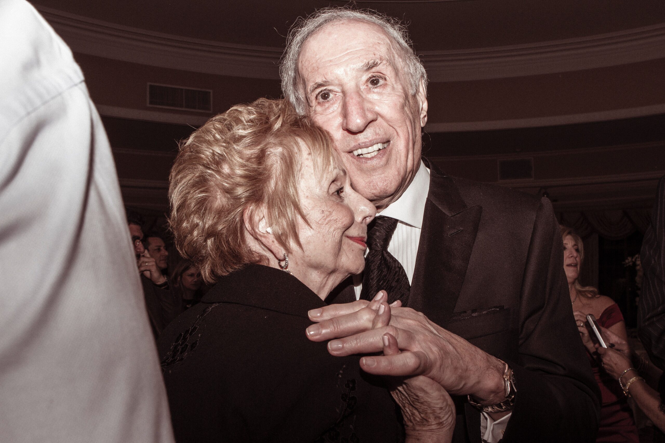 Older couple dancing together while holding hands and smiling