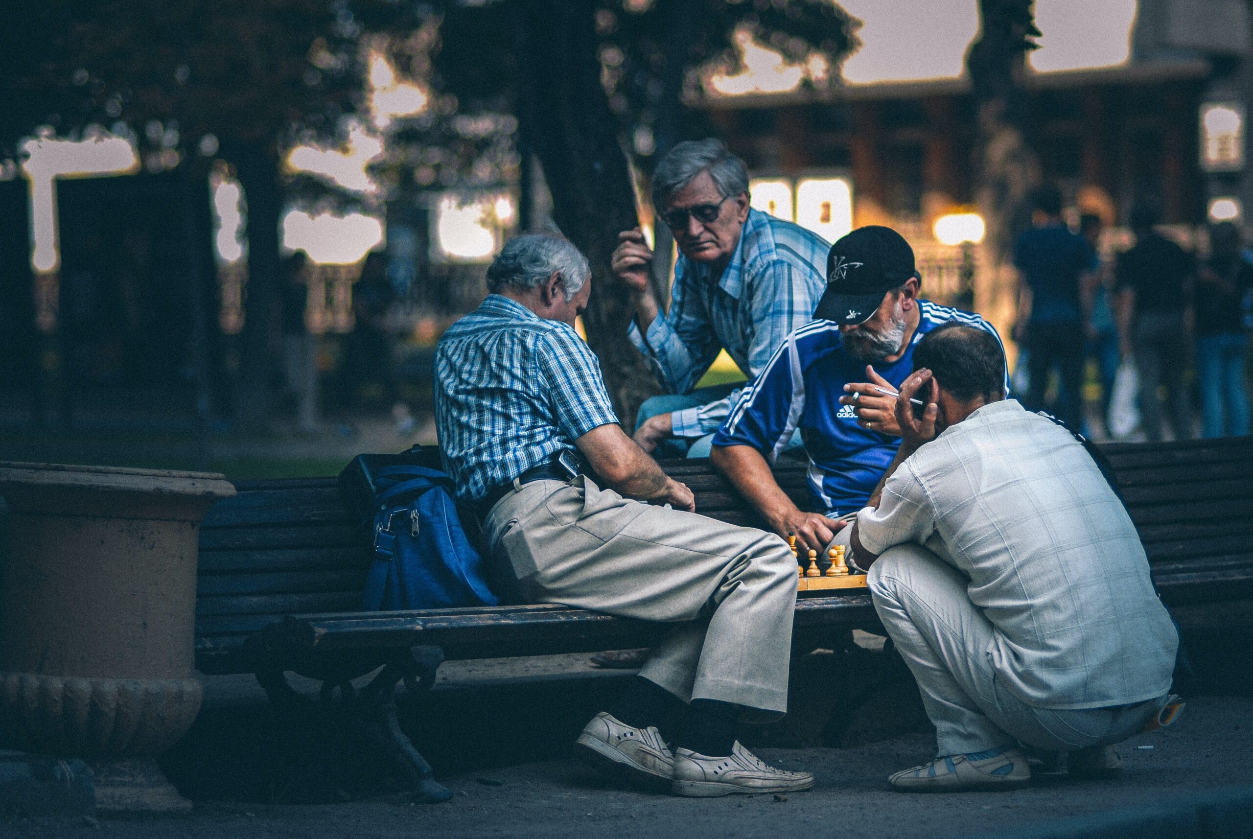 Mens Health. 4 men on park bench playing chess