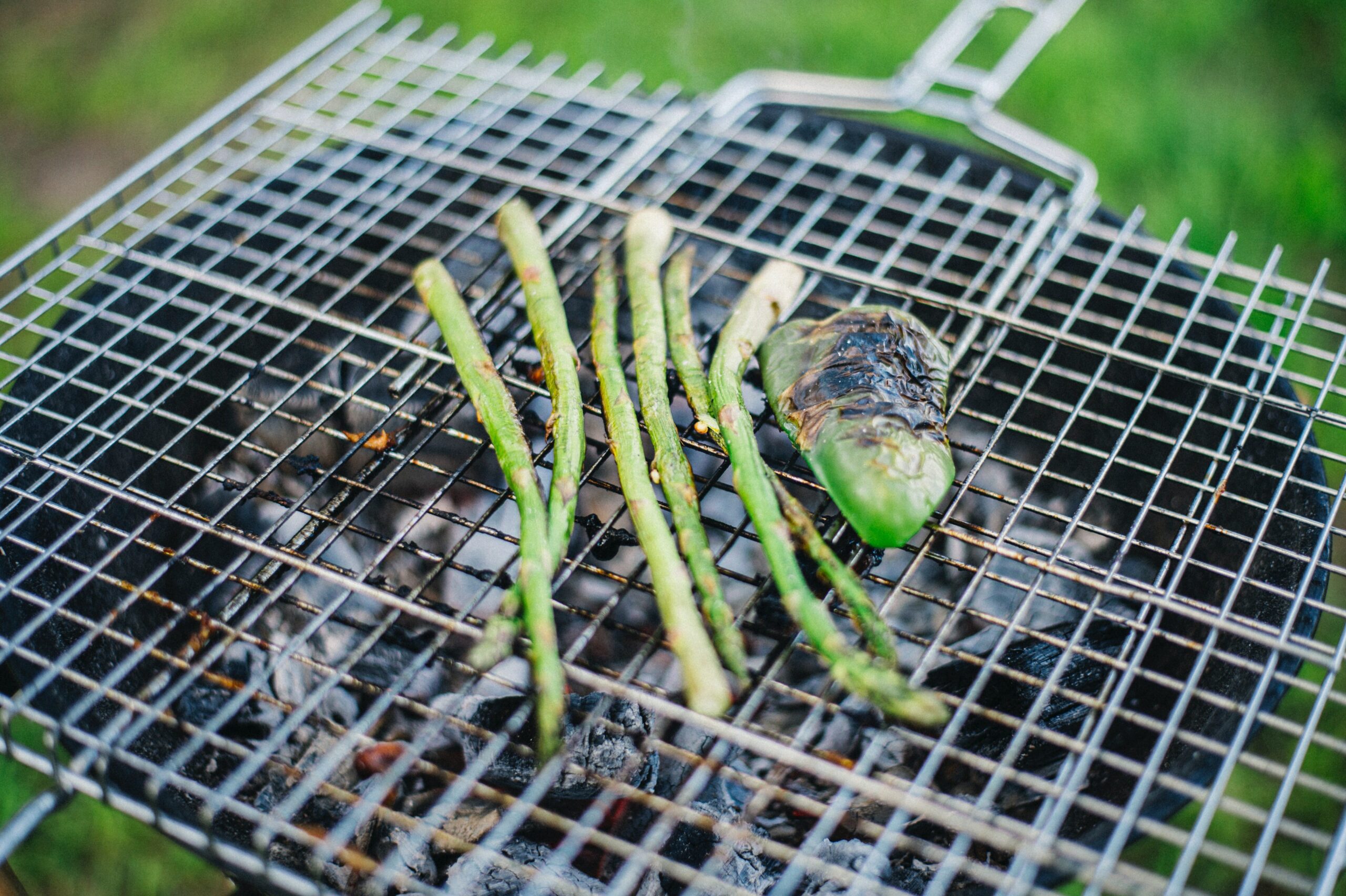 Grilled asparagus and pepper on iron rack resting on grill