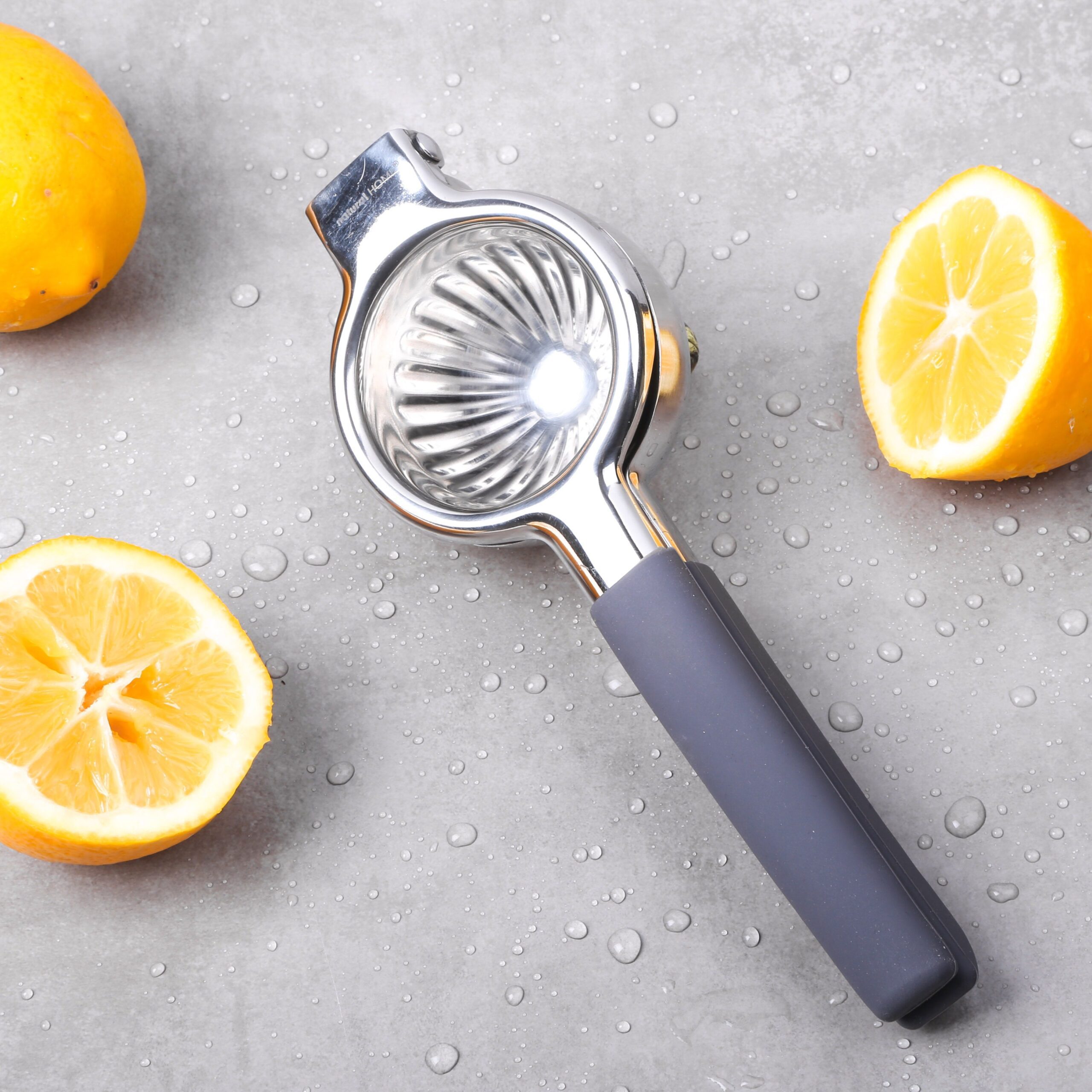 handheld fruit juicer with lemons on gray background