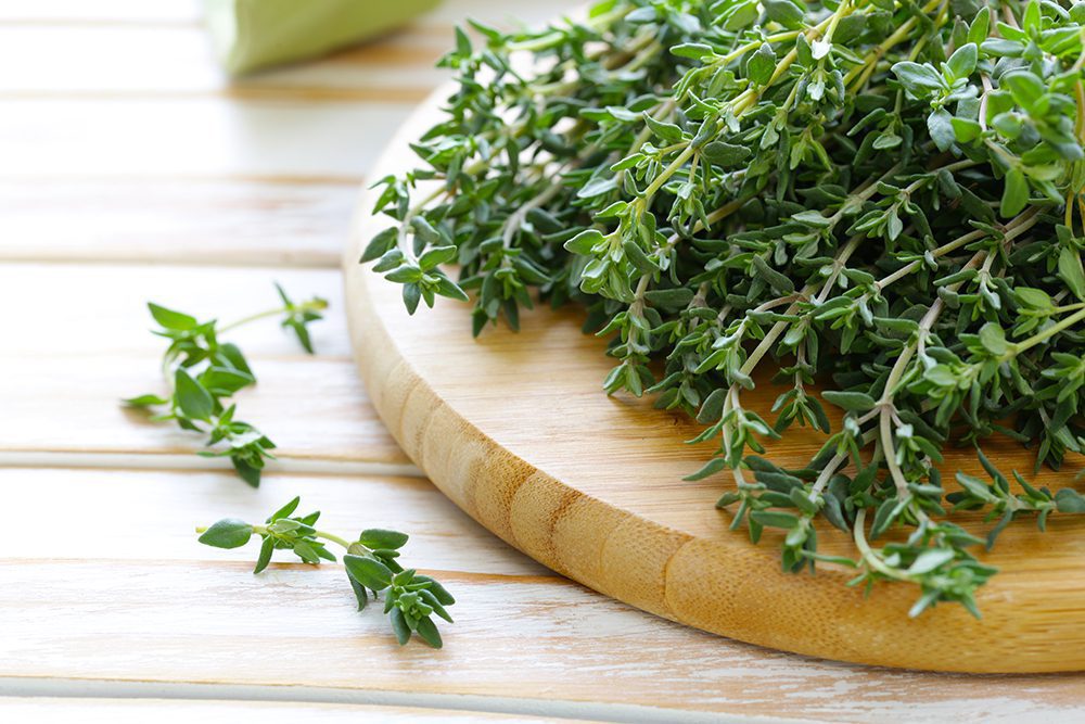Sprigs of thyme on wooden cutting board