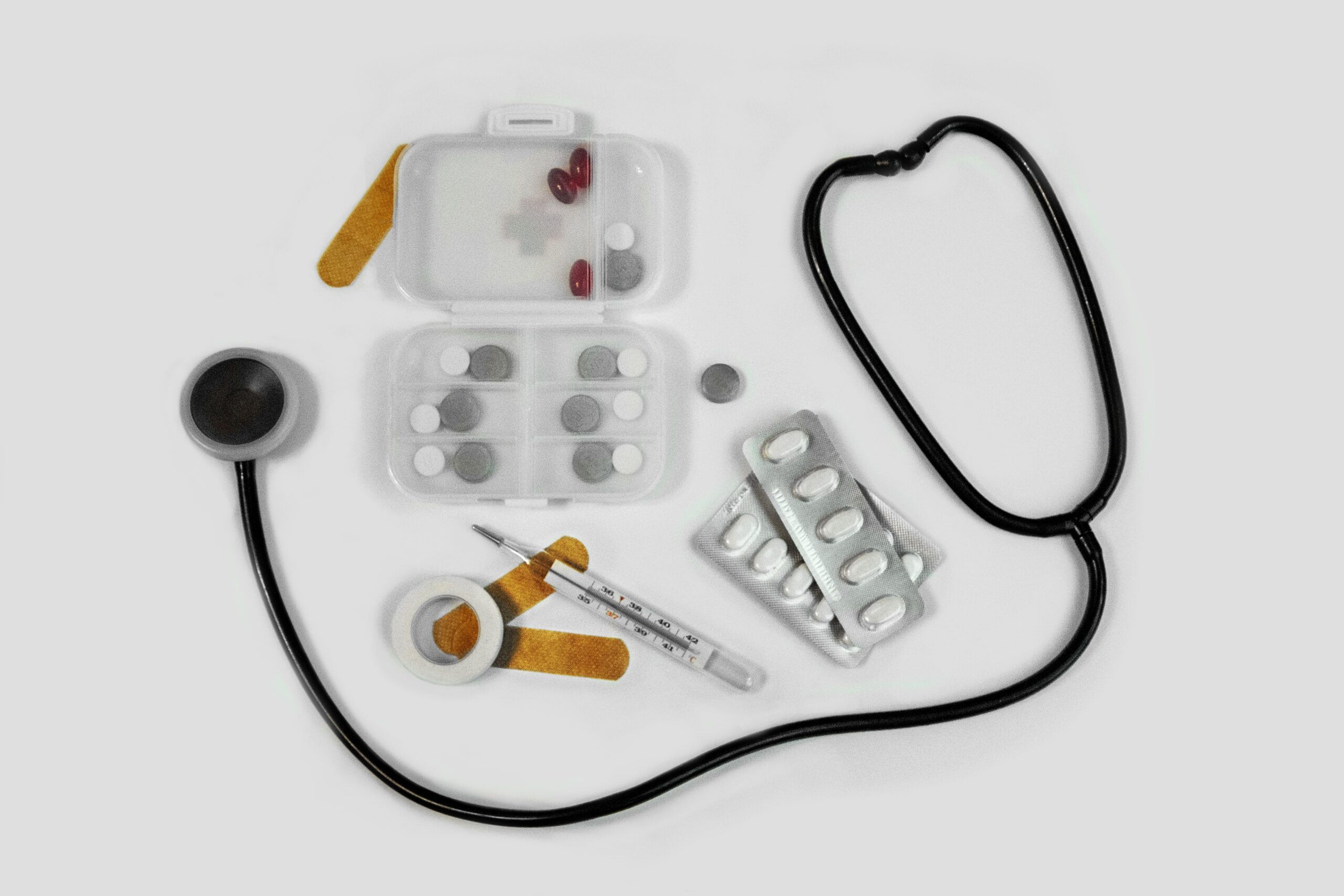 Photo of stethoscope, vitamins, bandages, and thermometer.