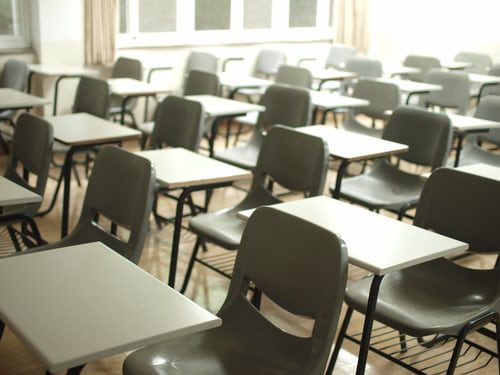 Empty classroom with desks and chairs in rows