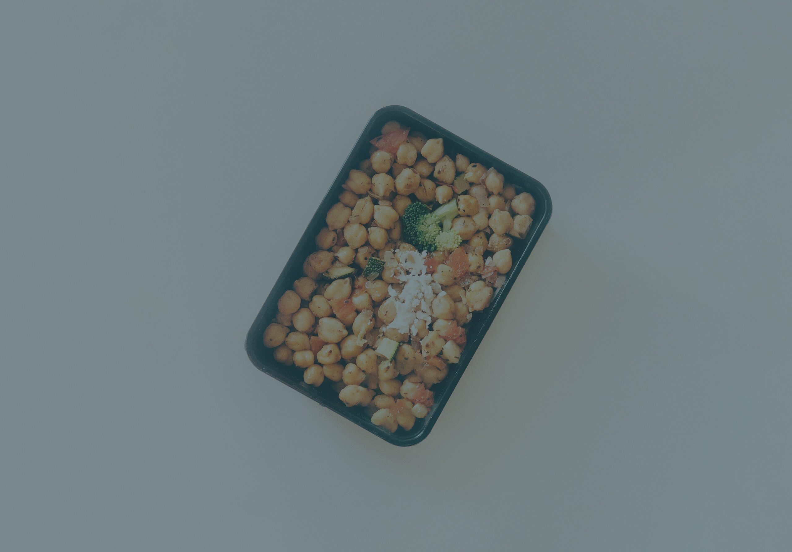 Grayed o9out photo of chickpeas and broccoli in a pan