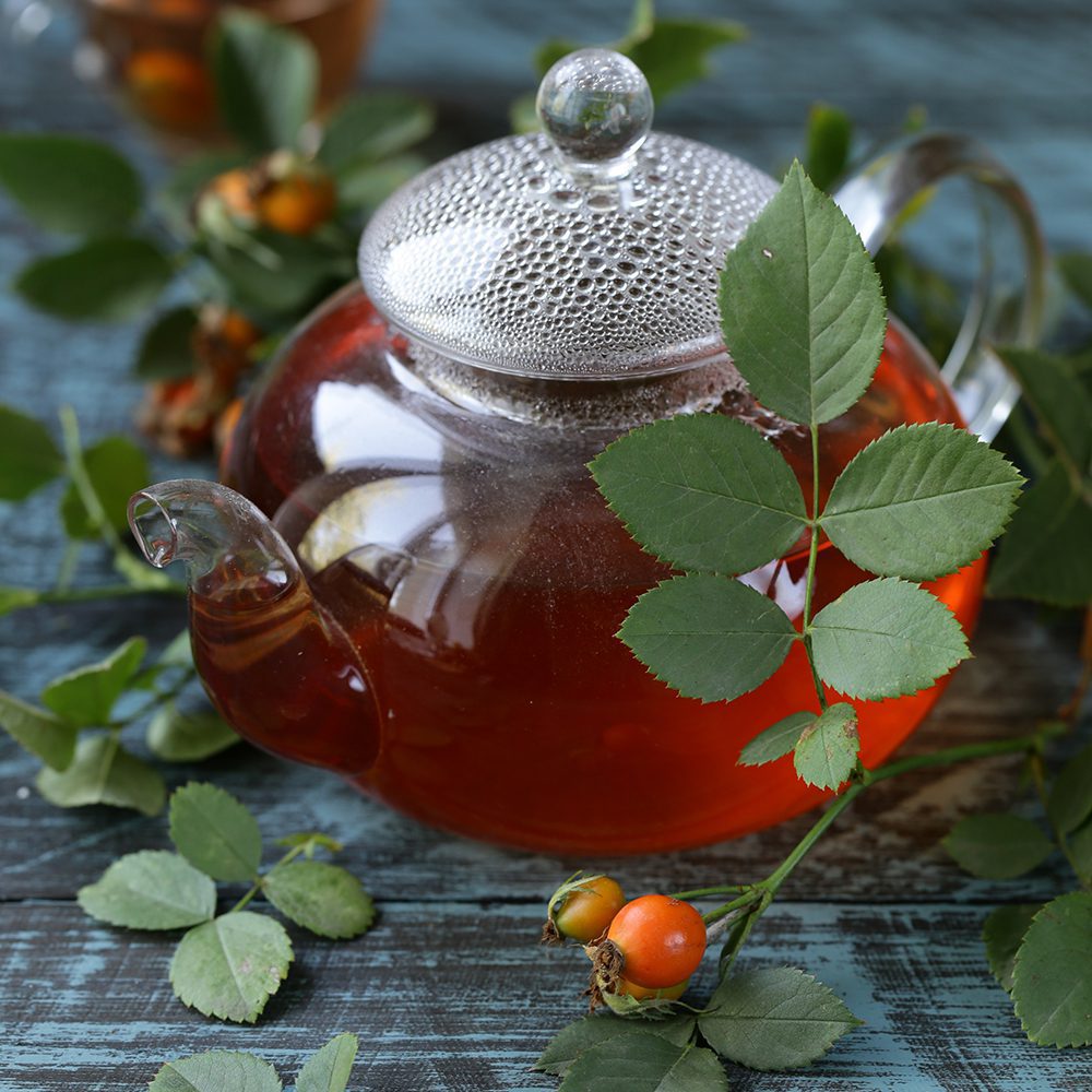 Glass teapot filled with red rosehip tea