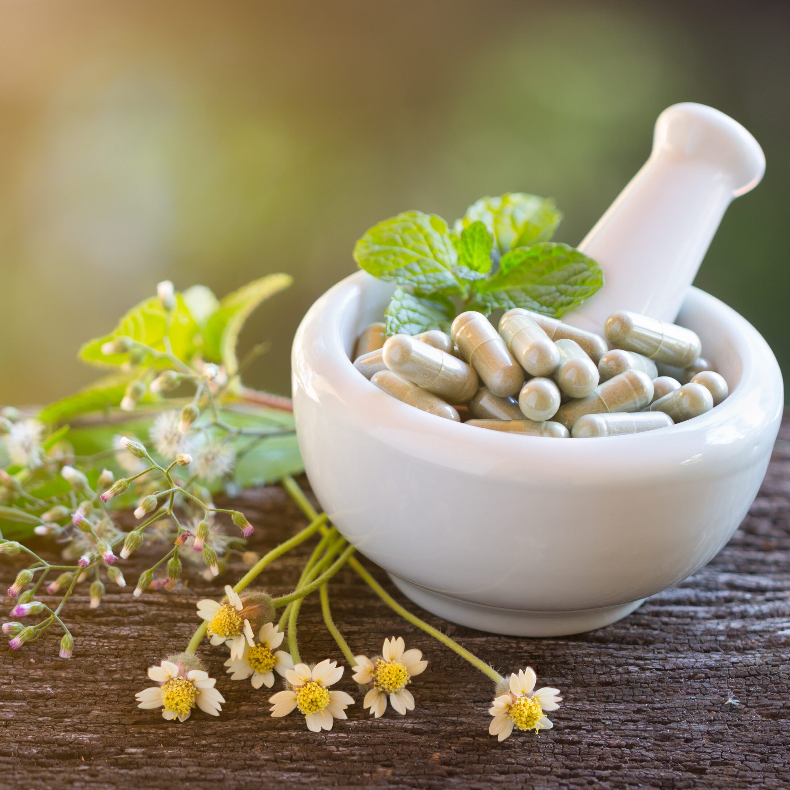 Herb Capsules in ceramic bowl with herbs and flowers decorating area